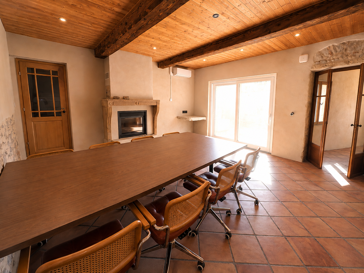 Grande table de travail partagée sous poutres et plafond bois