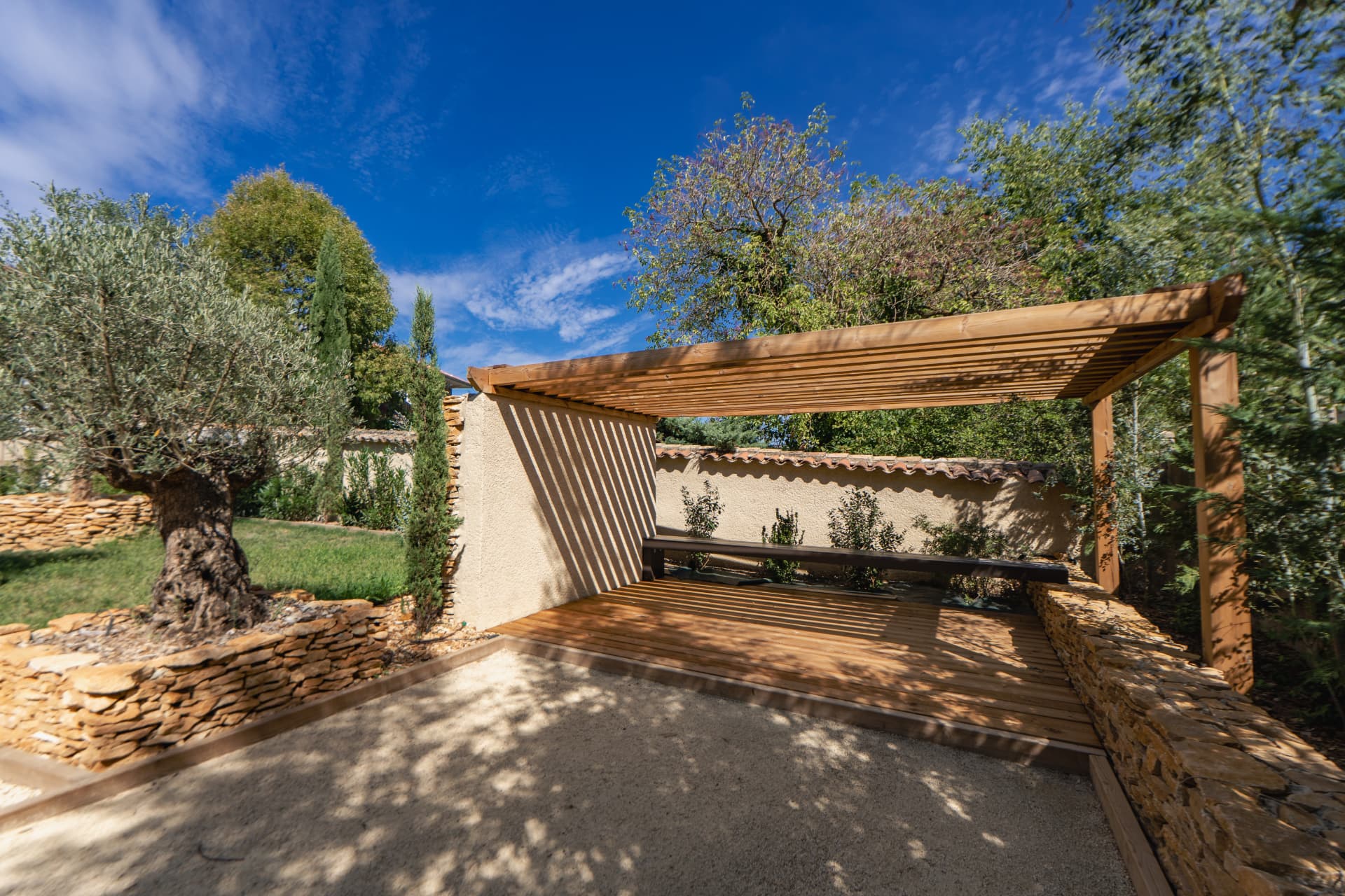 Pergola et banc en bois face aux oliviers