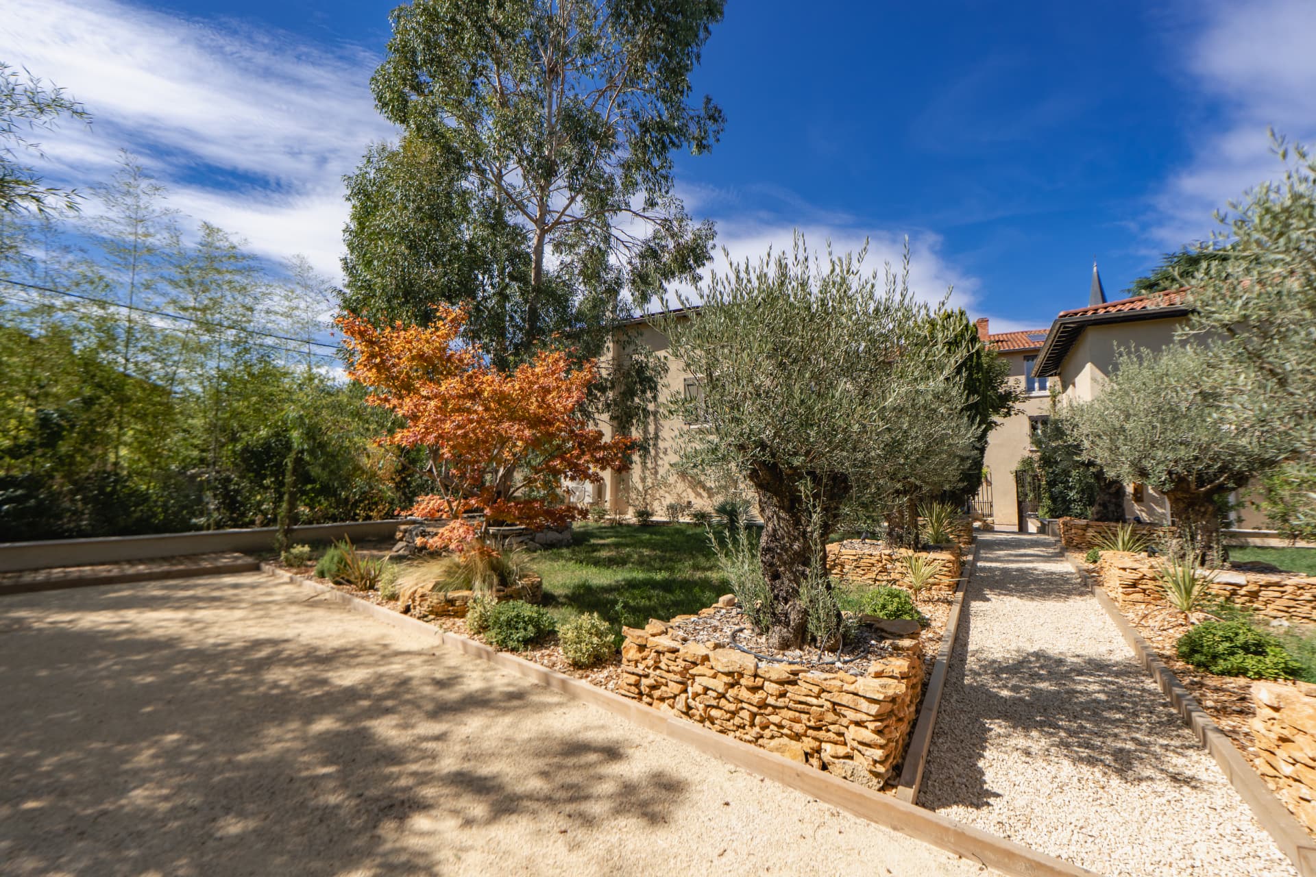 Jardin et bâtisse de la résidence vue depuis le terrain de pétanque